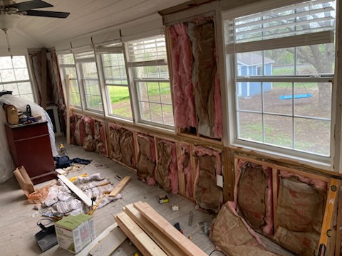 Sunroom mid-renovation with new insulation and windows